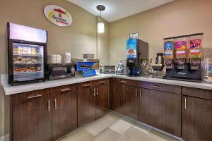 a fast food kitchen with a counter with food at Super 8 by Wyndham Palestine TX in Palestine