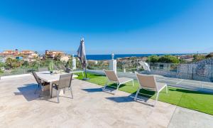 a patio with a table and chairs and a view at Top Renovated Villa with Sea-Views and Pool in Fuengirola