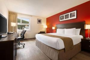 um quarto de hotel com uma cama grande e uma secretária em Travelodge by Wyndham Blairmore em Blairmore