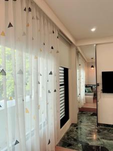 een kamer met een muur van gordijnen en een raam bij HoME-Easyhouse-III in Tainan