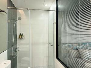台南的住宿－荷米.輕新館(三館)，一间带玻璃淋浴和卫生间的浴室