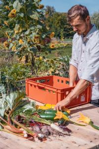 a man is cutting vegetables on a cutting board at Folwark in Wierzchowiska