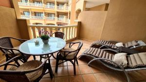 a balcony with a table and chairs and a building at Best4U Nautico in San Miguel de Abona