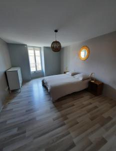 een slaapkamer met een groot wit bed en een televisie bij Maison centre saint Quentin en mauges in Saint-Quentin-en-Mauges