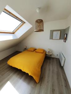 een slaapkamer met een geel bed en een raam bij Maison centre saint Quentin en mauges in Saint-Quentin-en-Mauges