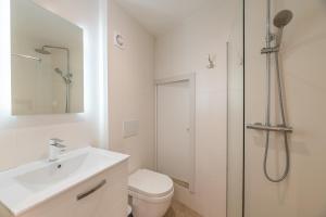 a white bathroom with a shower and a sink at RAVISSANT STUDIO RENOVÉ 150m DE MONACO in Beausoleil