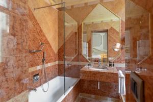 a bathroom with a tub, sink, and mirror at Hotel Colomba d'Oro in Verona