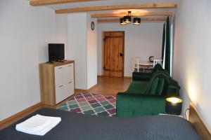 a living room with a green couch and a table at Dom Gościnny Grzęda in Jelenia Góra