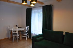 a living room with a green couch and a table at Dom Gościnny Grzęda in Jelenia Góra