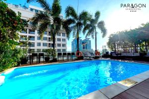 a large blue swimming pool in front of a building at Paragon Saigon Hotel in Ho Chi Minh City