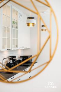 riflesso di una cucina in uno specchio di Apartament Golden Mirror z basenami, strefą saun,jacuzzi W CENIE!- Pinea Apartments Pobierowo-SANNEL Apartments for rent a Pobierowo