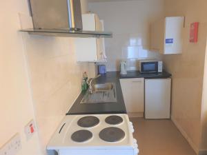 a small kitchen with a stove and a sink at 2 bedroom apartment in Greater Manchester in Ashton under Lyne