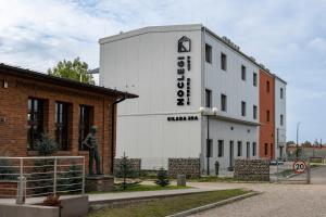 a white building with a statue in front of it at Przy Skarpie Rozbark in Bytom