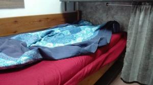 łóżko z drewnianą ramą z czerwonym kocem w obiekcie Стаи на пъпа на Варна, входа на Морската градина w Warnie