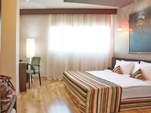 een slaapkamer met een groot bed en een raam bij Design Hotel Mr President in Belgrado