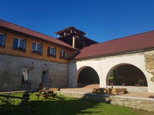 a courtyard of a building with a table and benches at Penzion Tvrz Dub u Tábora in Ratibořské Hory