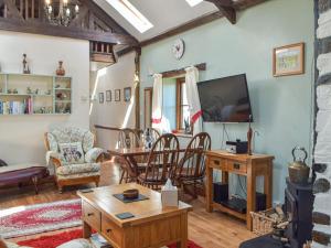 a living room with a tv and a table and chairs at Swallow Barn in Haverfordwest