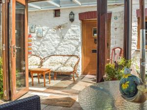 a patio with two chairs and a glass table at Swallow Barn in Haverfordwest