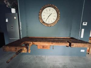 a large clock on a wall above a wooden table at Apartament na Ogrodowej in Nidzica