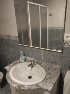 een badkamer met een wastafel en een spiegel bij Fuentinueva in Ampuero