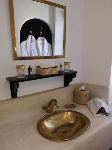 a sink in a bathroom with a mirror at Riad de charme l'Oasis d'Essaouira - Suite Luxe in Essaouira