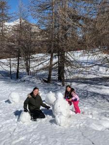 twee mensen die in de sneeuw spelen met een sneeuwpop bij T3 puy st Vincent 1800 in Puy-Saint-Vincent