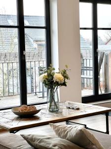 una sala de estar con una mesa con un jarrón de flores en SEEBADHOF Berlin-Rangsdorf, en Rangsdorf