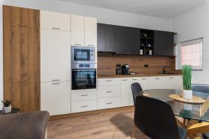 a kitchen with white cabinets and a table with chairs at La Luna - High-end 2BD Flat in the TOP centre by Flat Mаnager in Sofia +22 photos