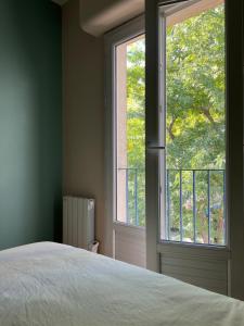 a bedroom with a bed and a large window at Appart'Alencon in Alençon