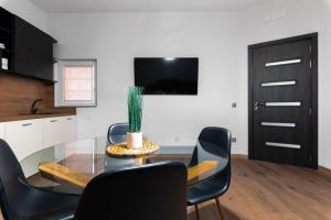 a dining room with a glass table and black chairs at La Luna - High-end 2BD Flat in the TOP centre by Flat Mаnager in Sofia