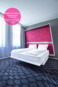 a bedroom with a large bed with a pink headboard at Magic Hotel Xhibition in Bergen