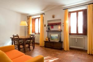 uma sala de estar com uma mesa e uma televisão em Residenza Porta all'Arco em Volterra