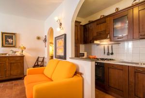 uma cadeira laranja numa cozinha com armários de madeira em Residenza Porta all'Arco em Volterra