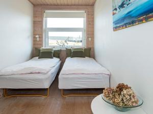 2 Betten in einem Zimmer mit einem Tisch und einem Fenster in der Unterkunft Holiday home Fanø CLXXVIII in Fanø