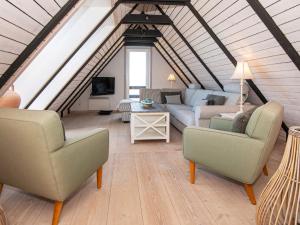 ein Wohnzimmer mit Sofas und Stühlen im Dachgeschoss in der Unterkunft Holiday home Fanø CLXXVIII in Fanø