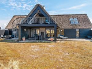 ein großes Haus mit einem Strohdach in der Unterkunft Holiday home Fanø CLXXVIII in Fanø