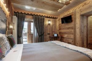 a bedroom with a large bed in a room with wooden walls at Cervinia Ski Apartment François - Private Hot Tub & Mountain View in Breuil-Cervinia