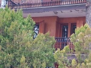 a house with a balcony and trees in front of it at Casa D'Amato Roccaraso in Roccaraso
