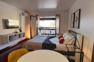 a bedroom with a bed and a table and a window at Health Village Apartments in Cascais +75 photos