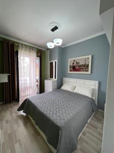 um quarto com uma cama e uma parede azul em Downtown Grand Comfort em Tirana