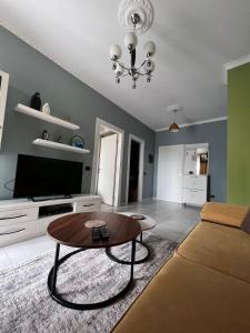 uma sala de estar com um sofá e uma mesa em Downtown Grand Comfort em Tirana