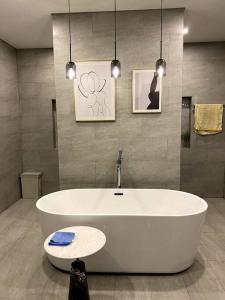 bañera blanca en el baño con 2 fotografías en Biệt thự nghỉ dưỡng mặt biển, cao cấp và riêng tư en Ba Ria