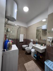 bagno con servizi igienici, lavandino e specchio di Downtown Grand Comfort a Tirana