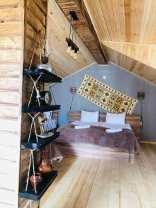 een slaapkamer met een bed en een houten plafond bij Hotel Nestt in Kazbegi