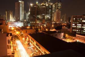 eine nachts beleuchtete Stadt mit Gebäuden und Straßenbeleuchtung in der Unterkunft M Suites Hotel in Manila