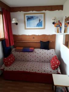 a bed with polka dot pillows in a bedroom at T3 puy st Vincent 1800 in Puy-Saint-Vincent