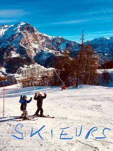 two people on skis in the snow in front of a mountain at T3 puy st Vincent 1800 in Puy-Saint-Vincent