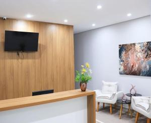 a waiting room with a flat screen tv on a wall at VR2 Hotel in Lençóis Paulista