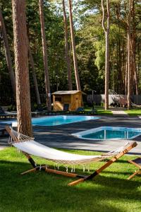 a hammock in the grass next to a swimming pool at Seaside Harmony in Pogorzelica