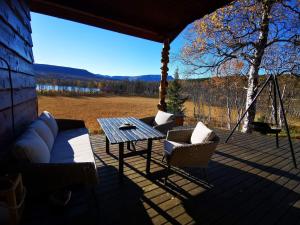 eine Veranda mit einem Tisch und Stühlen sowie Aussicht in der Unterkunft Cosy cabin in North-Norway, Nearby Senja. in Sorreisa
